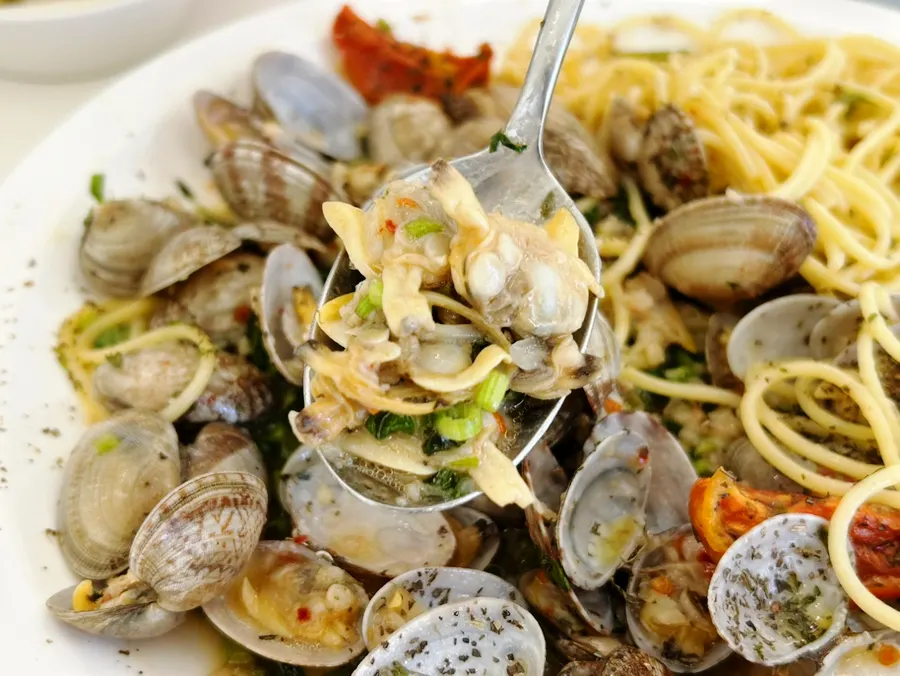 Vongole pasta noodles topped with minari
