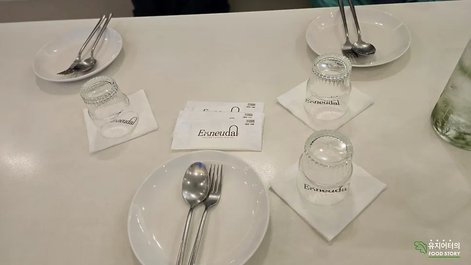 접시와 물, 피클이 놓인 어느달 테이블 세팅