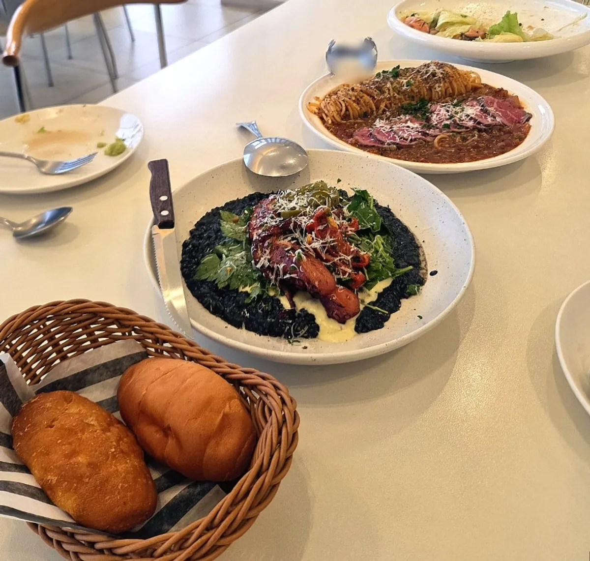 Table set with the risotto, salad, and pasta ordered by three diners at Eoneu Dal