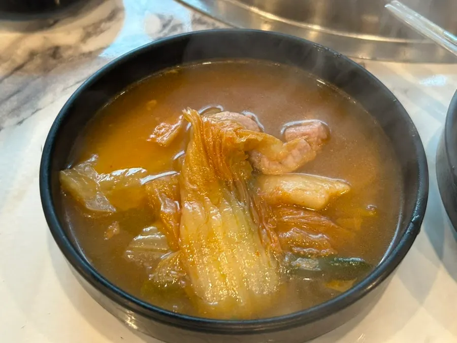 Kimchi jjigae in a stone pot served as a standard side