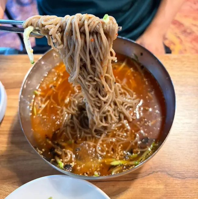 젓가락으로 들어올린 메밀면