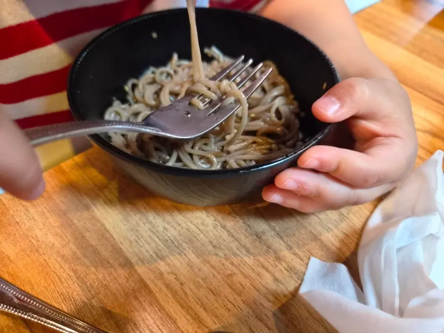 Twins eating mul makguksu from paper cups