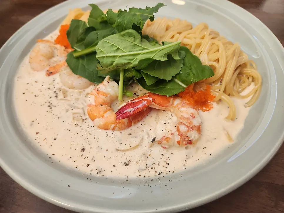 Table spread with red shrimp pasta and salad