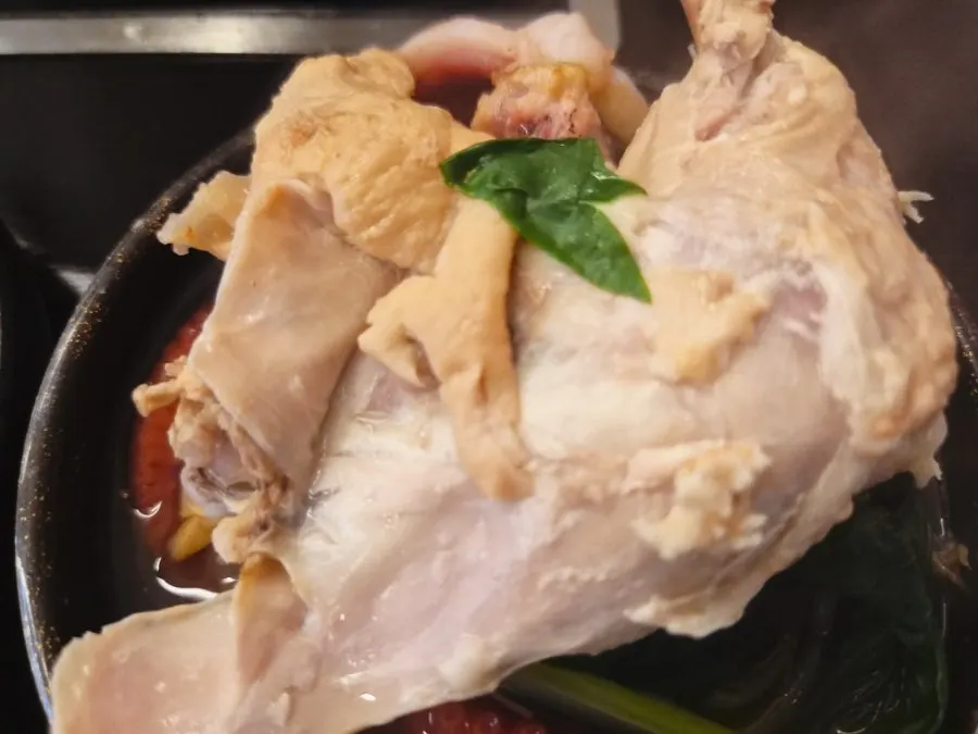 Chicken meat picked up with chopsticks