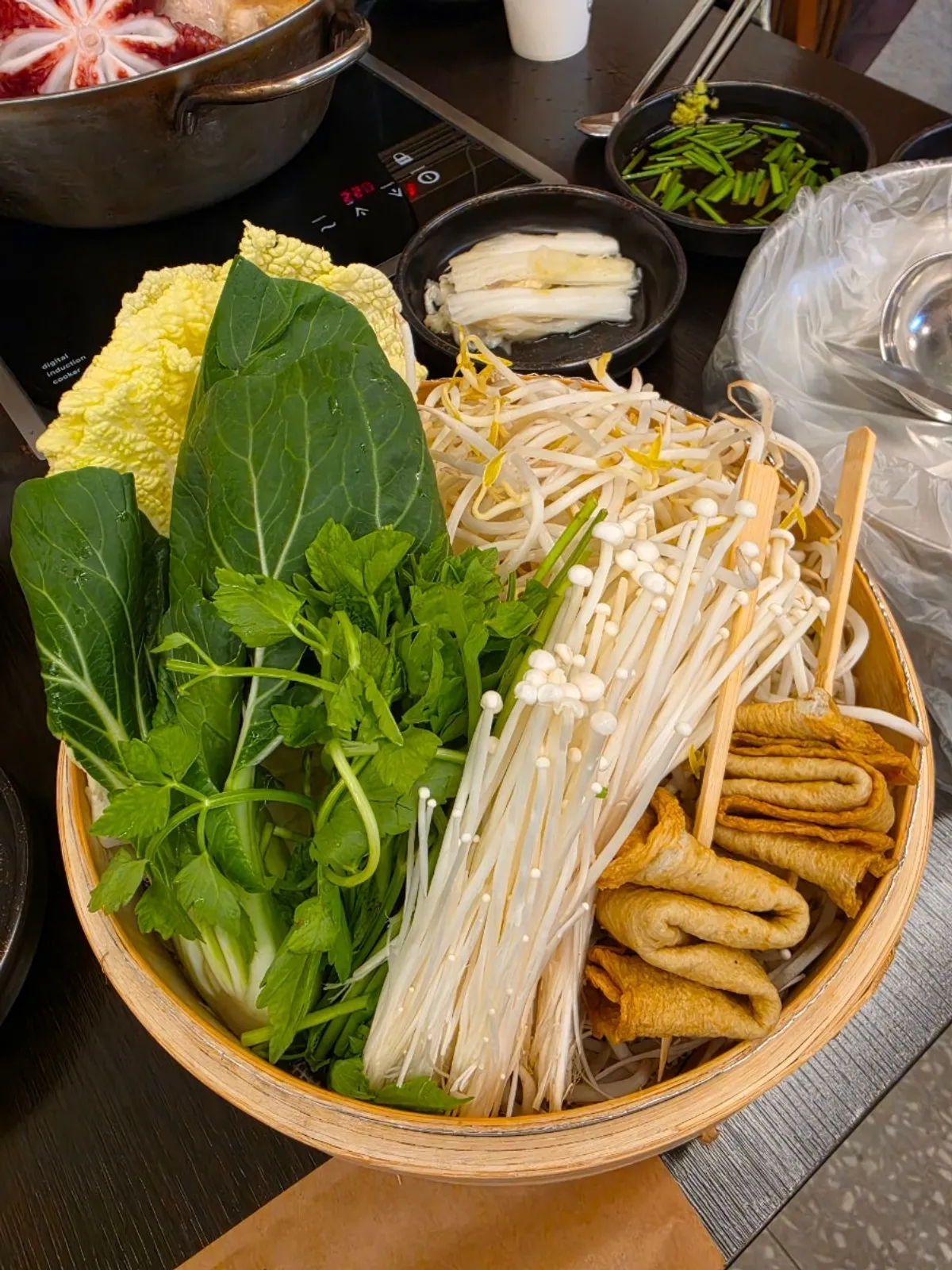 Pot filled with chicken and seafood alongside a vegetable basket
