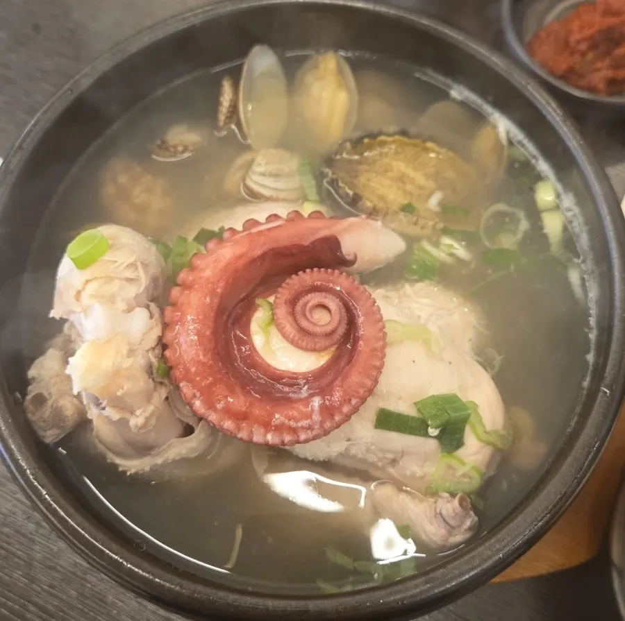Pot of samgyetang topped with seafood