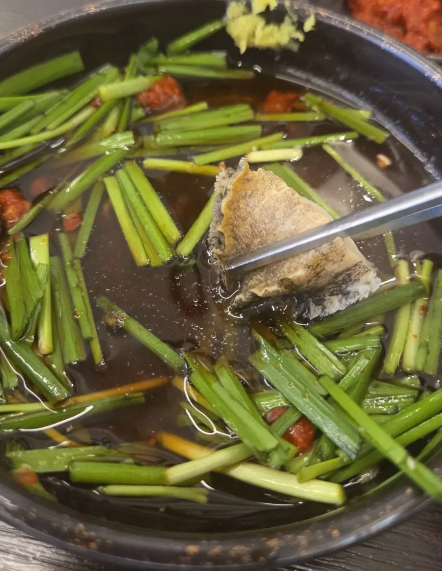 A piece of samgyetang dipped in sauce