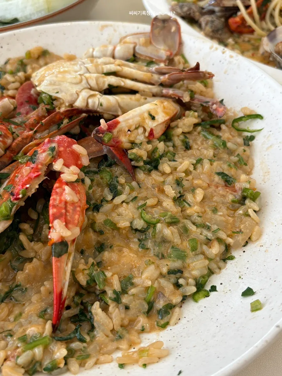 A spoonful of blue crab risotto soaked in bisque sauce