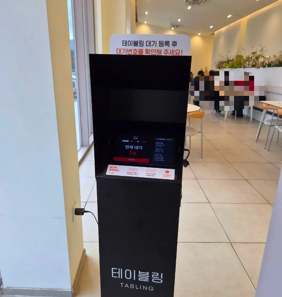 Restaurant entrance with a table-management kiosk