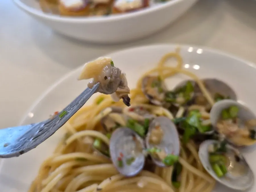 Vongole pasta topped with minari