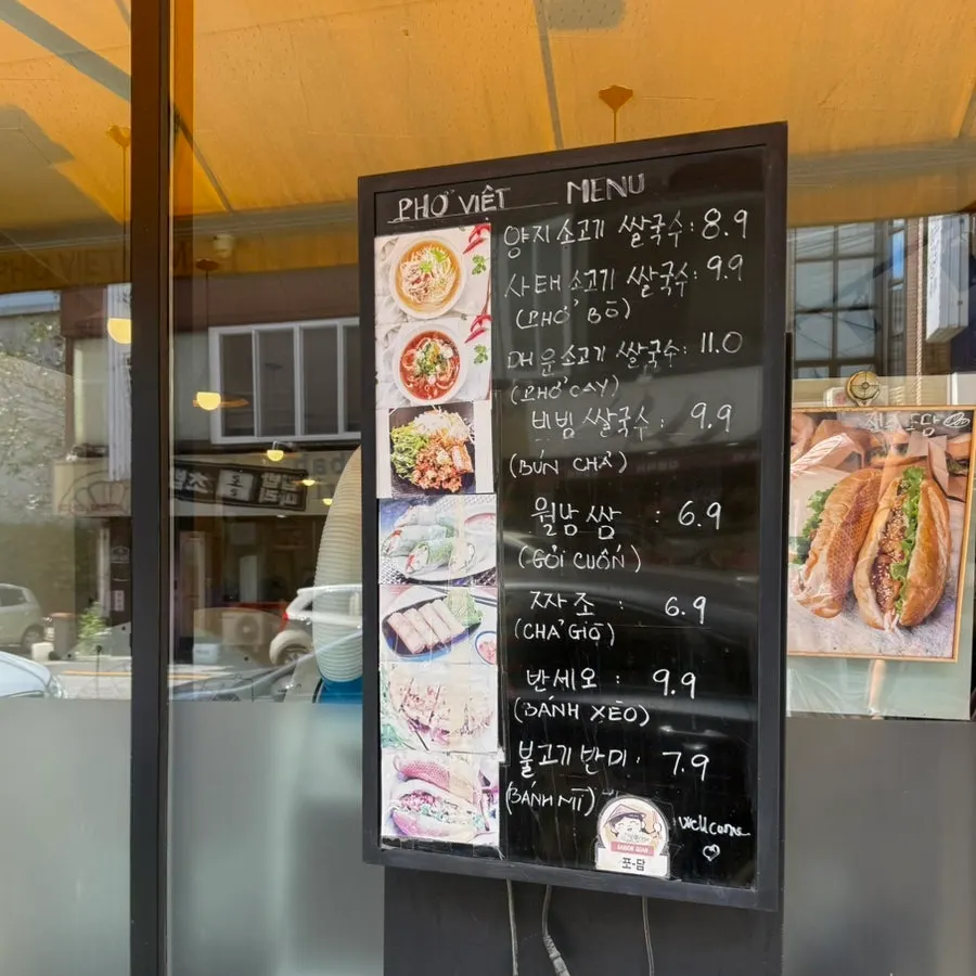 Menu board with pho and side dish prices at Phodam