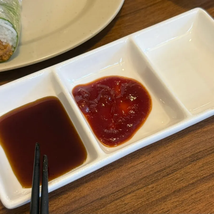 Spicy chili sauce and a darker sauce on the table