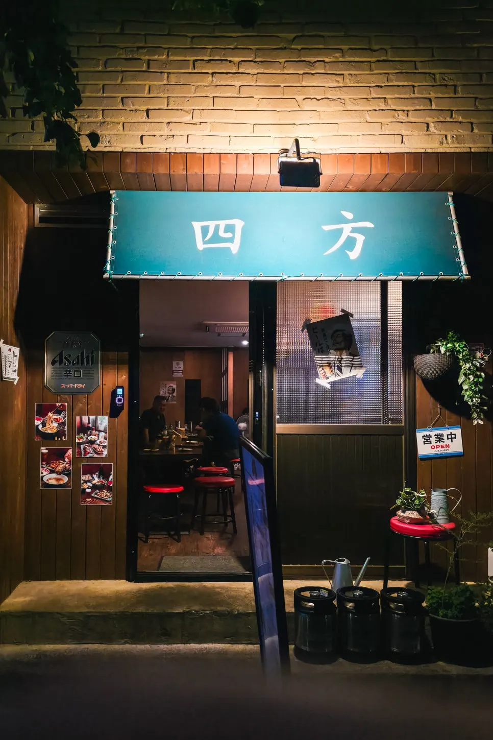 Yomo's entrance with a teal awning and red brick exterior