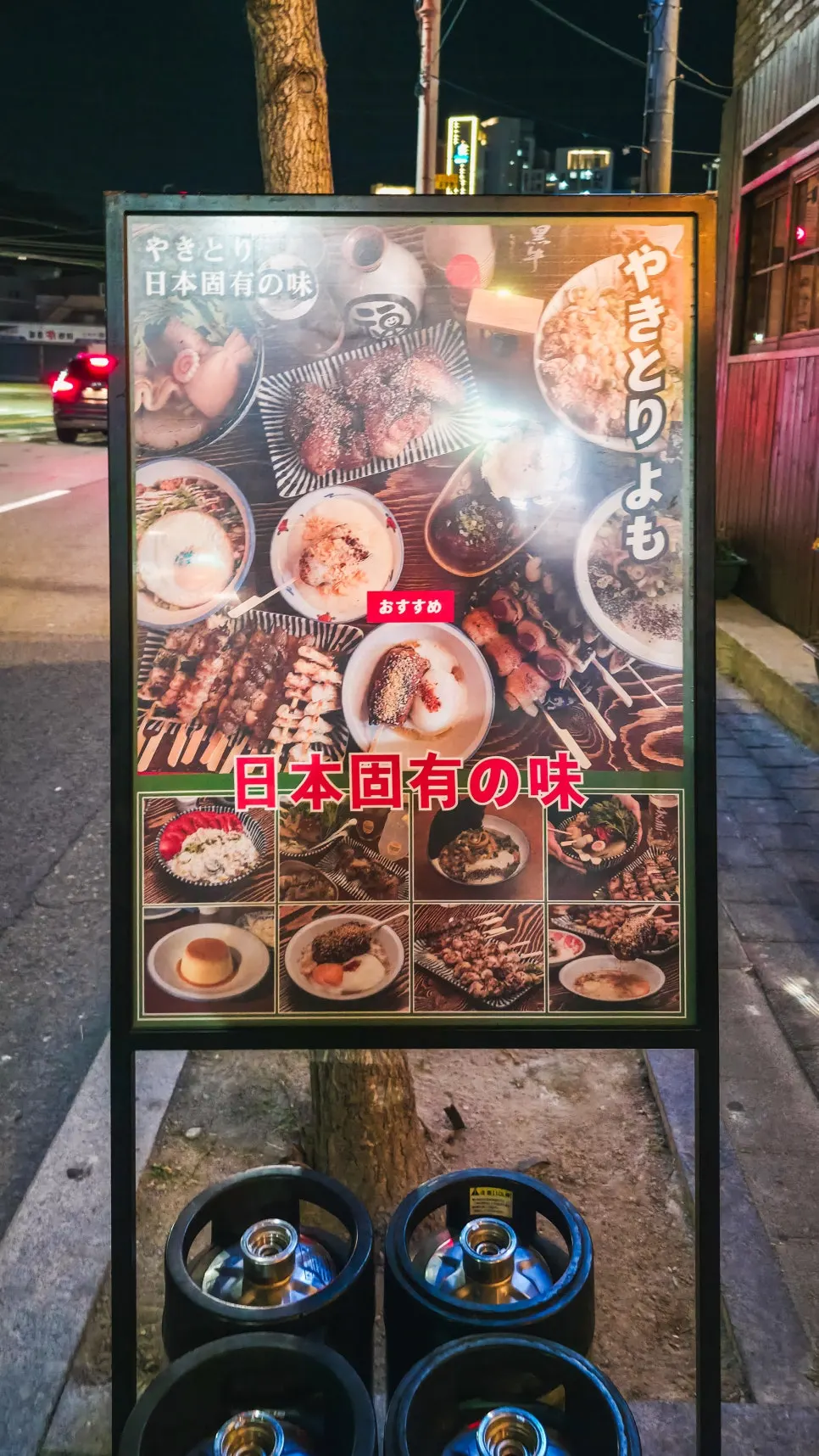 Yakitori Yomo's signboard and draft beer kegs