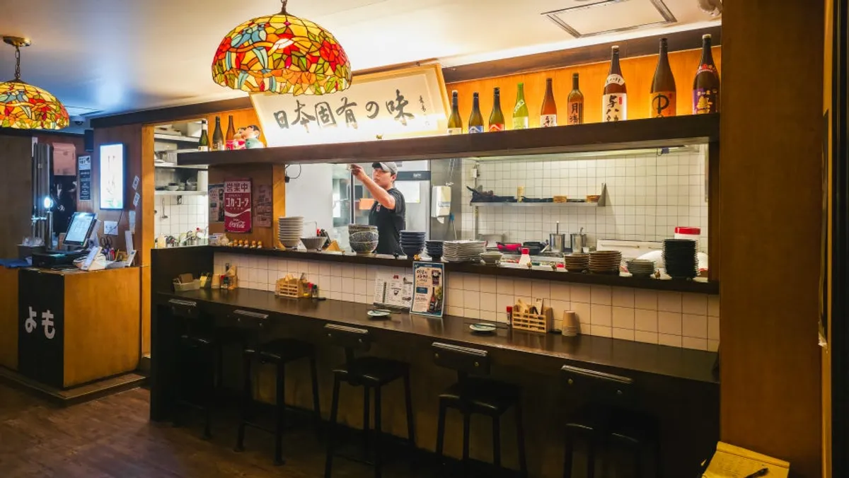 Wood-toned bar counter lit by stained-glass lighting