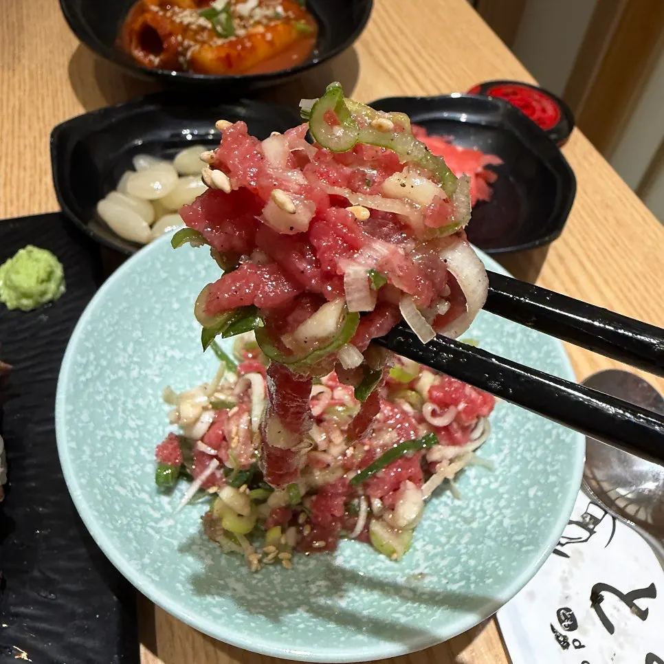 Complimentary dishes including spicy raw fish salad and fried food