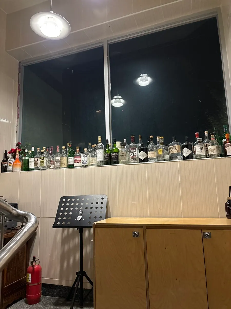 Whiskey and gin display along the window of the stairway to the 2nd floor