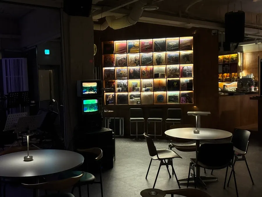 Wall covered in LP records with bar stools in front