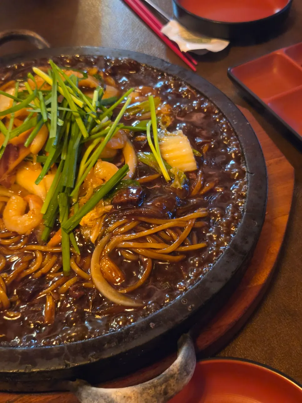 Stone-plate jjajang bubbling on the hot stone at Hwamok