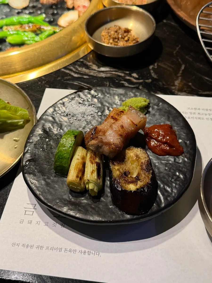 A bite of pork belly topped with wasabi and pollack roe