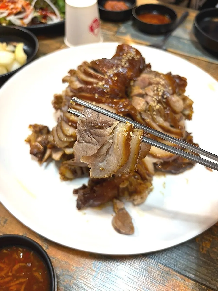 A piece of jokbal held with chopsticks
