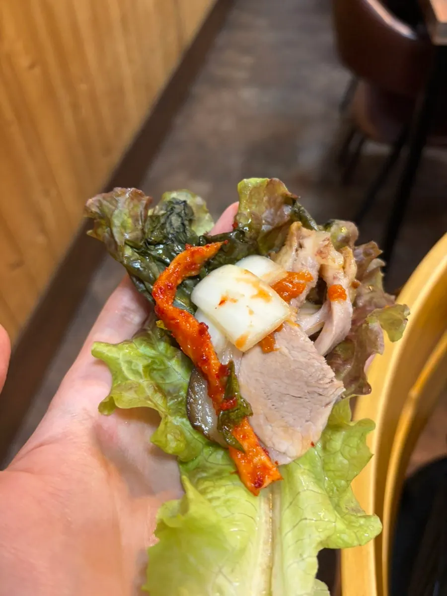Jokbal placed on wrap vegetables with ssamjang