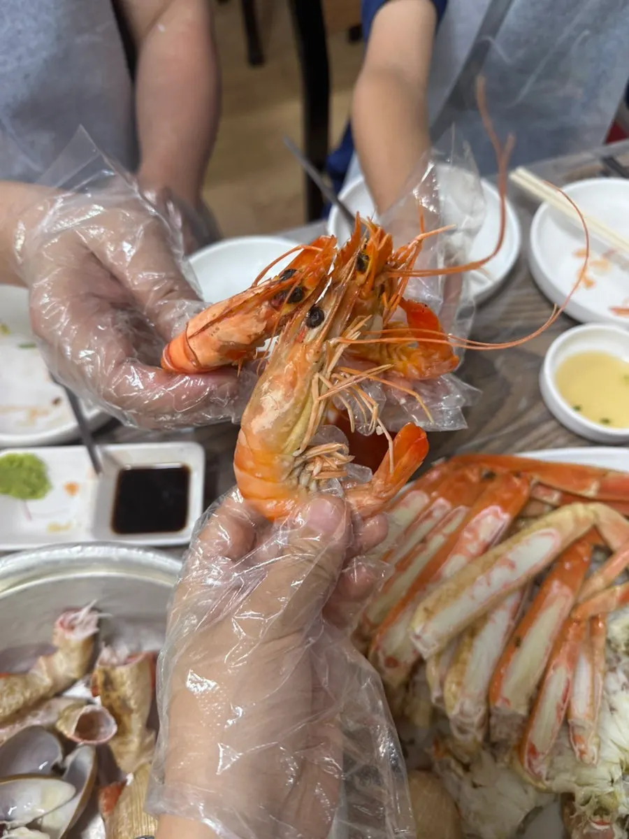 Isi kaki bakdal daegae yang dikopek dengan sarung tangan