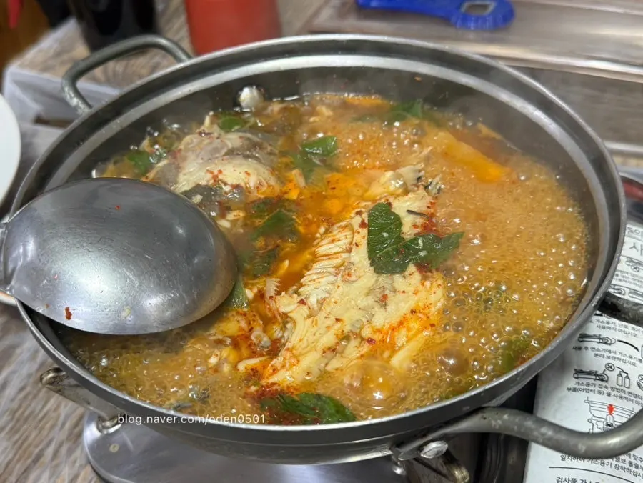 Pot of spicy fish stew topped with red chili powder