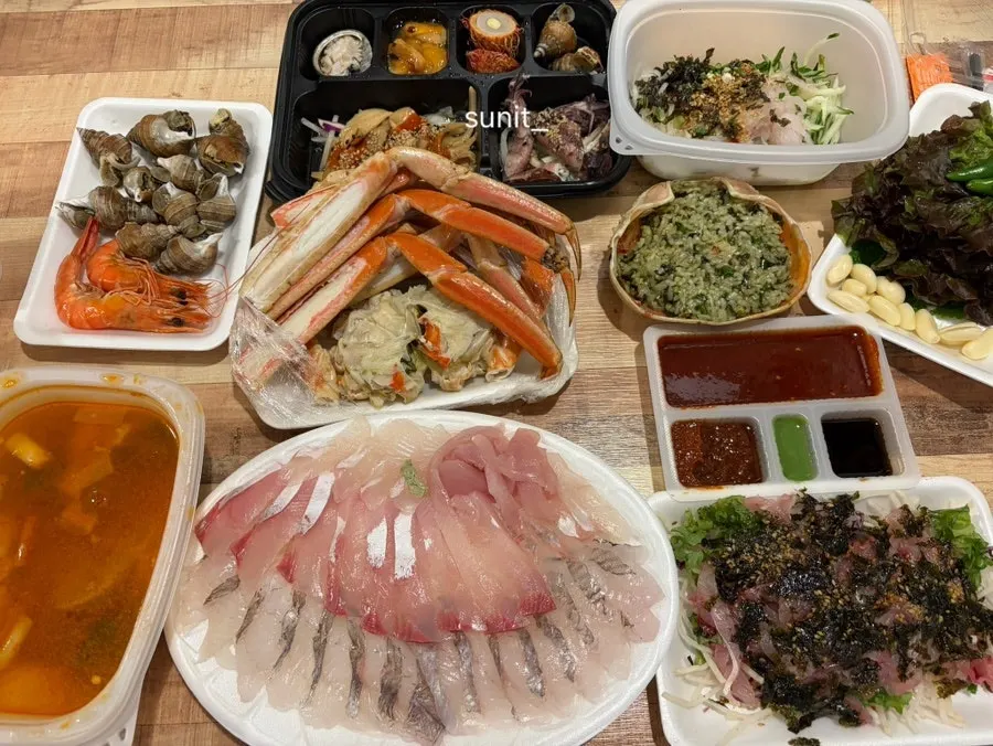 Full spread of bakdal snow crab, assorted sashimi, and mulhoe