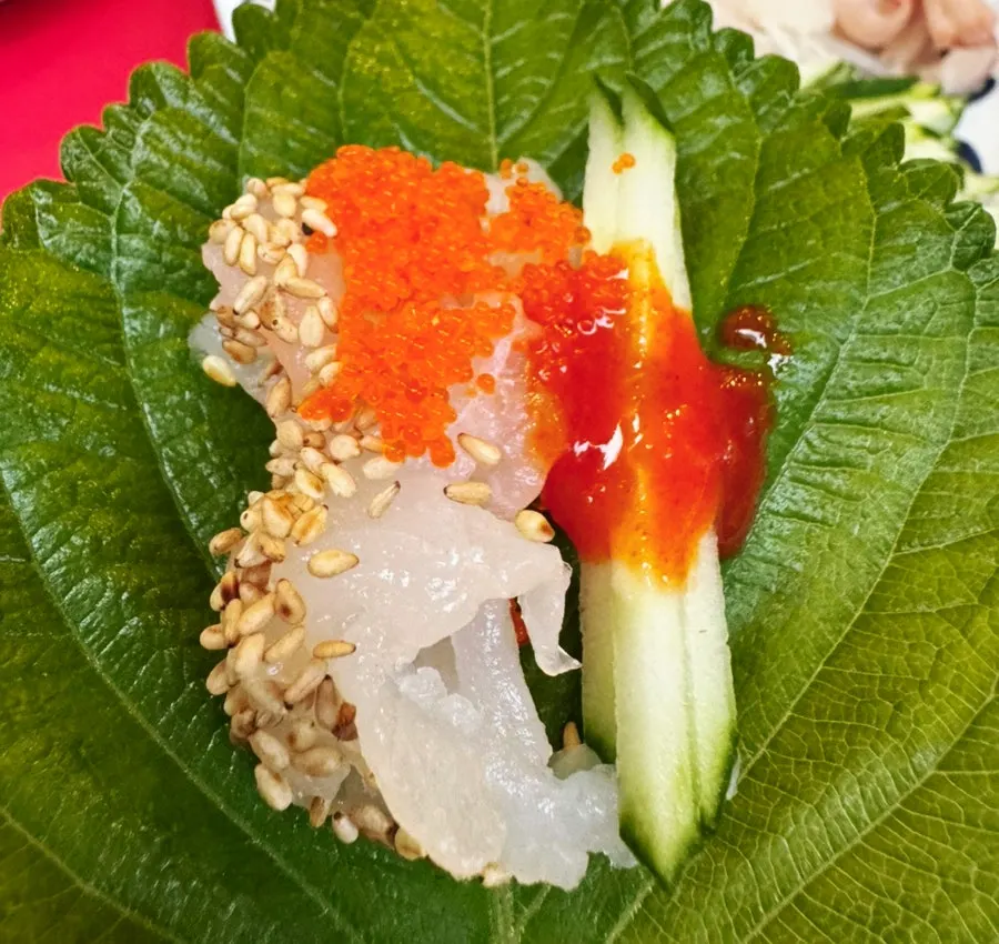 A perilla leaf wrap with makhoe, garlic, and chili