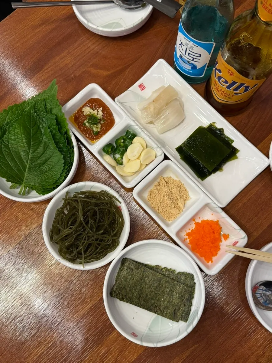 Basic banchan for makhoe: perilla leaf, gim, seaweed salad, flying fish roe and more