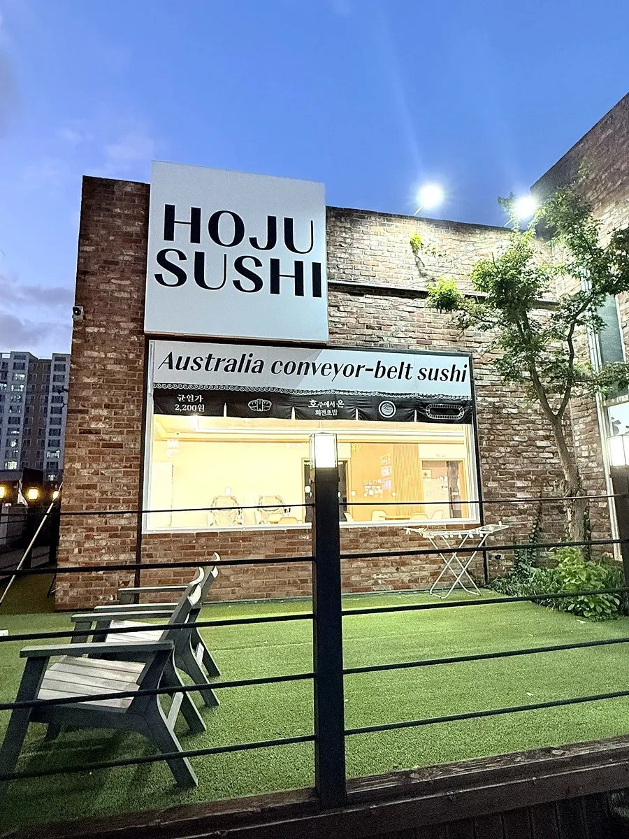 Evening view of the conveyor sushi restaurant's red-brick exterior