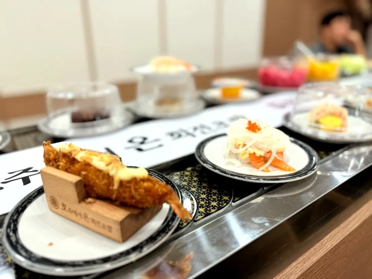 Various sushi plates circling on the rail