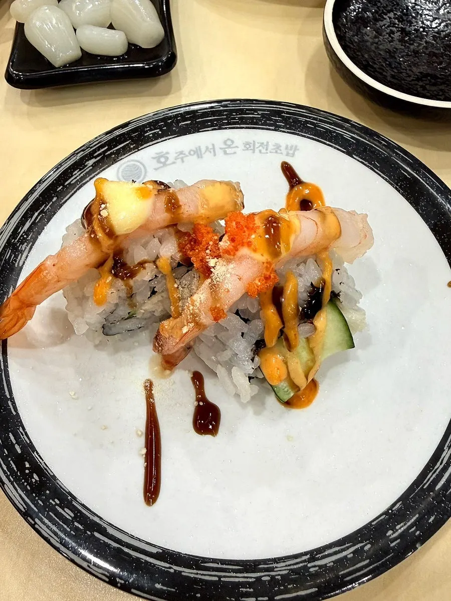Sushi on a flat-rate plate with a black rim