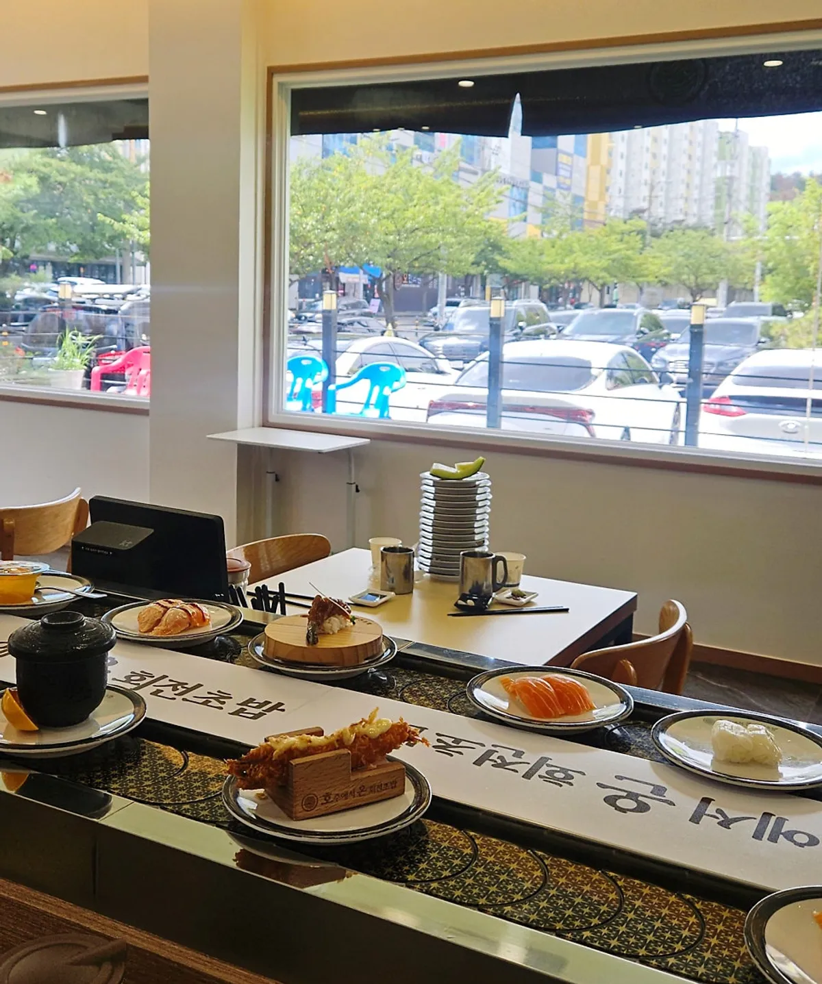 둘이 앉은 회전초밥 레일 옆 바 자리