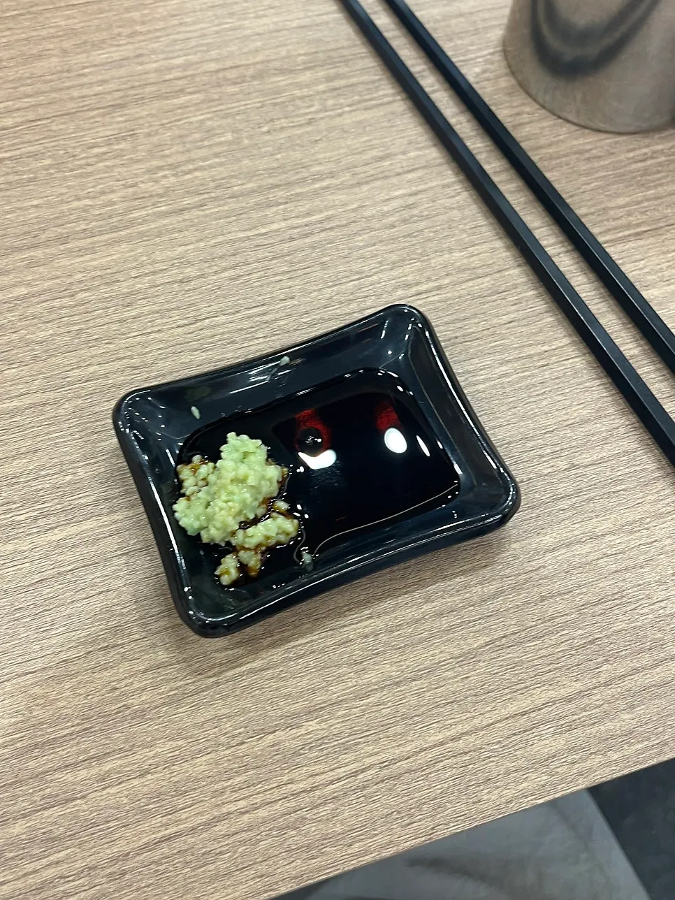 Table set with udon broth, soy sauce, and wasabi