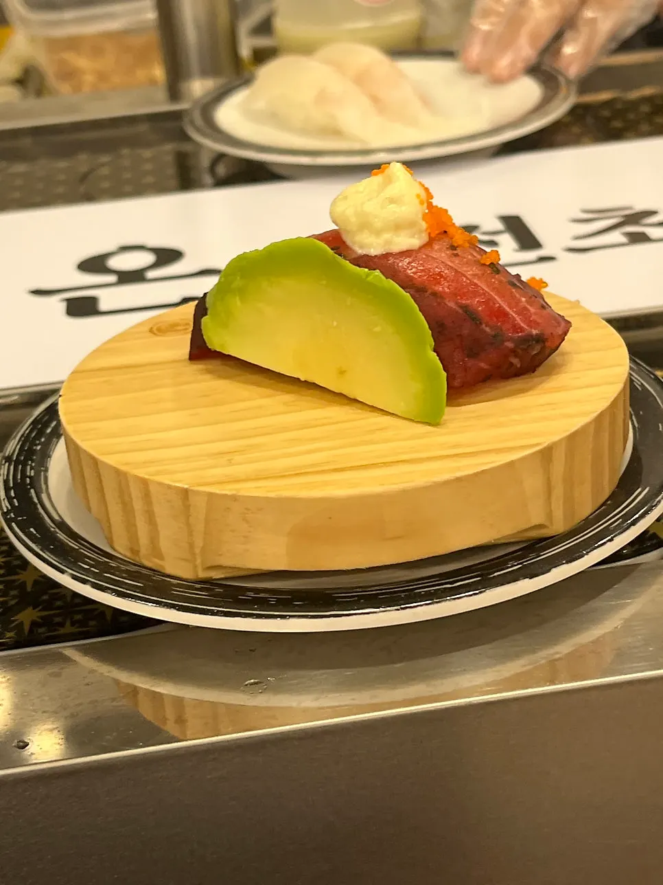 Avocado gravlax salmon sushi passing on the belt