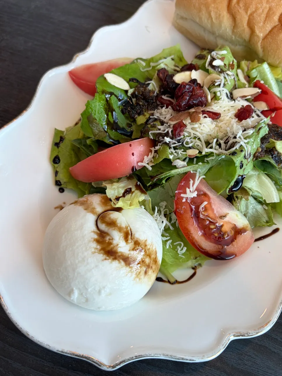 Plate of salad with the chewy burrata cheese cut open