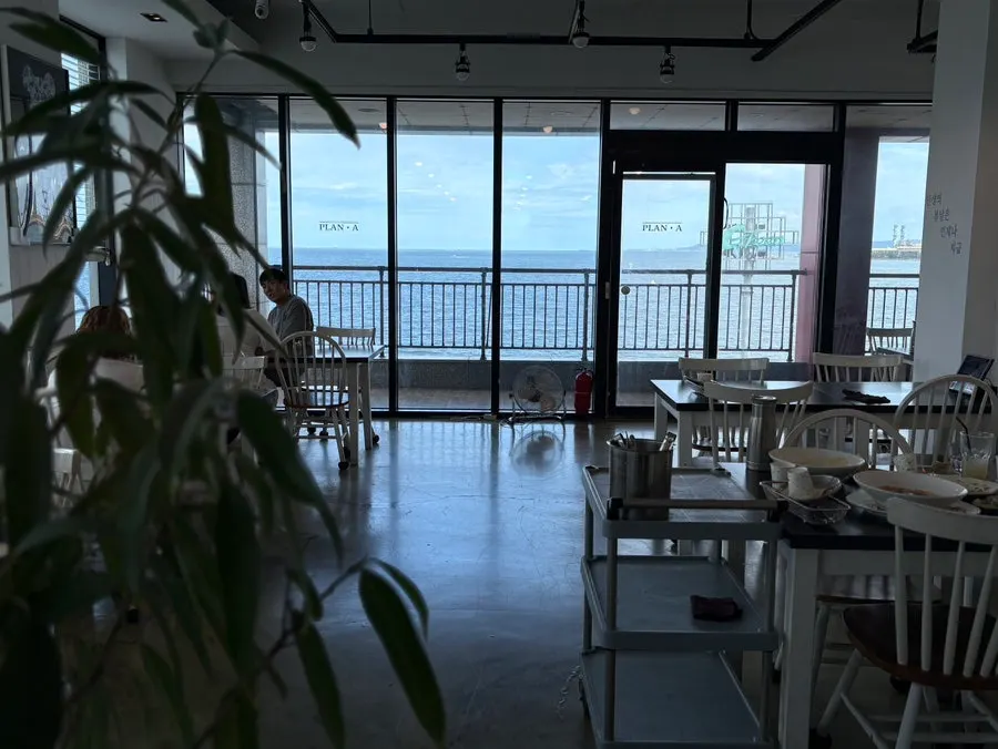 Wide view of the interior of Plan A Restaurant with the sea in view