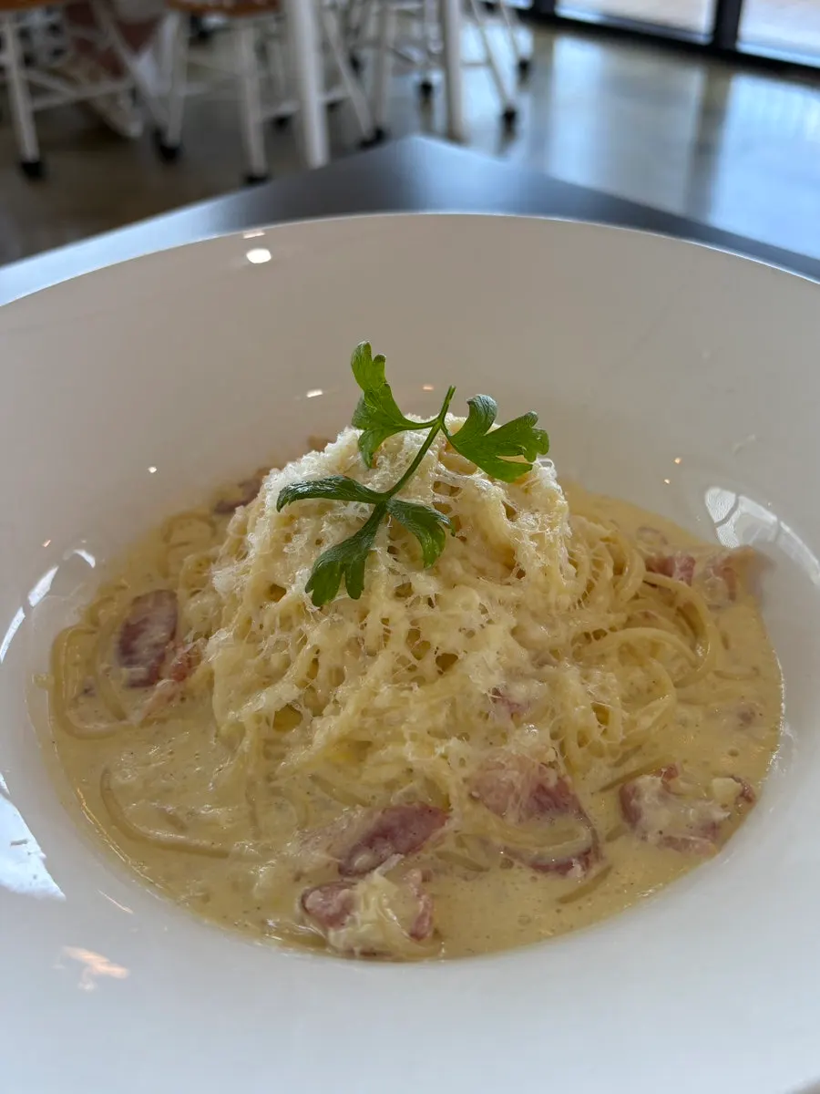 Close-up of carbonara topped with bacon and cheese