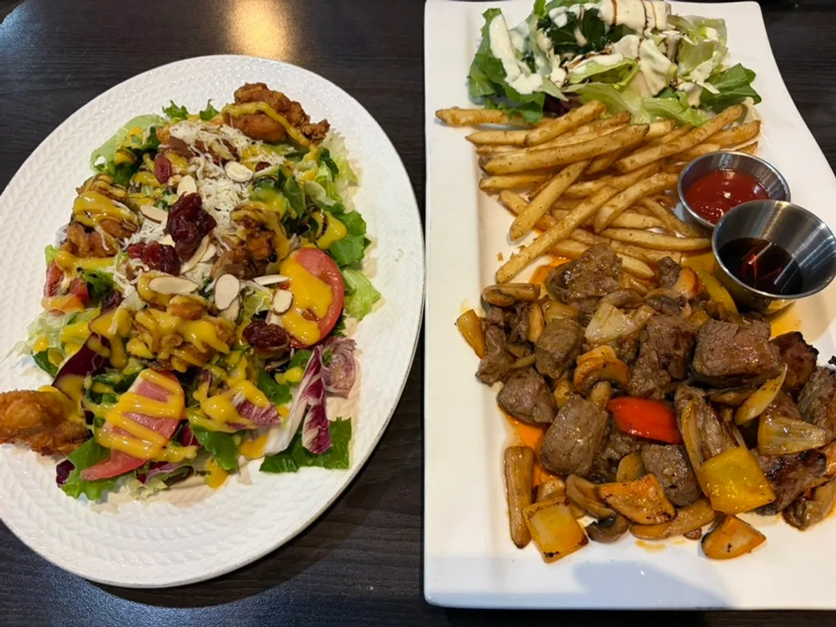 Table set with beef chop steak and chicken salad