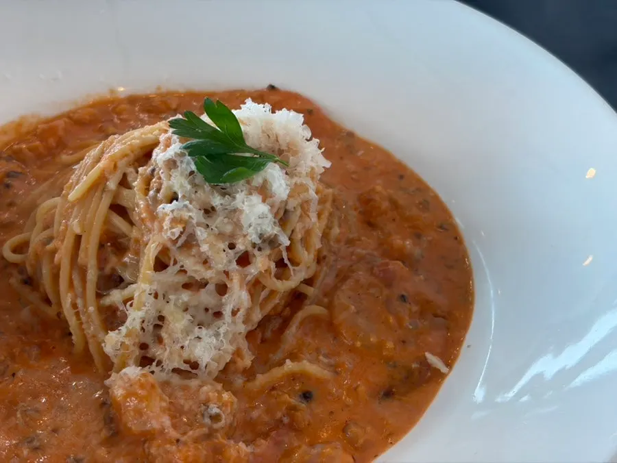 Plate of shrimp rosé spaghetti sprinkled with snow cheese