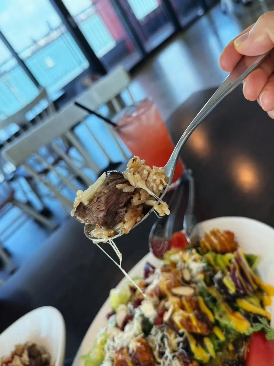 A spoonful of beef pilaf with a cheesy finish