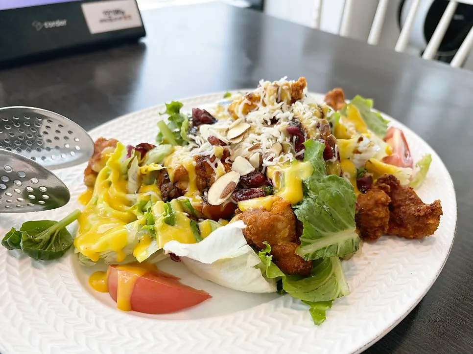 Close-up of chicken salad topped with sliced almonds and cheese