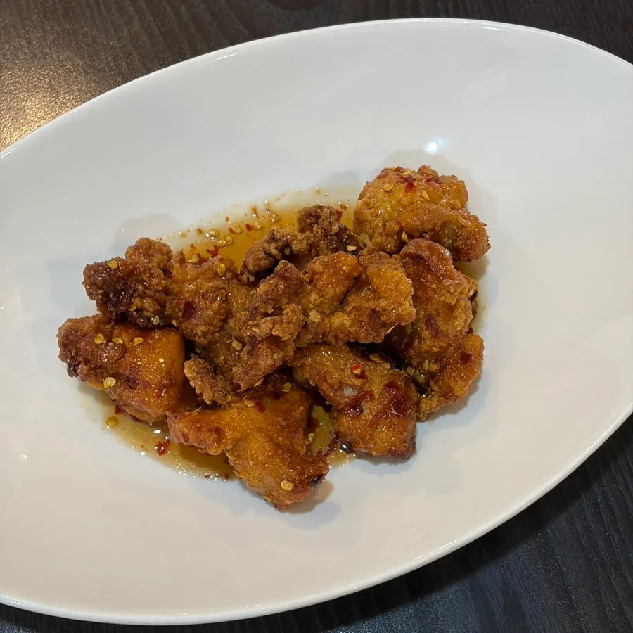 Close-up of crispy fried chicken coated in spicy chili sauce
