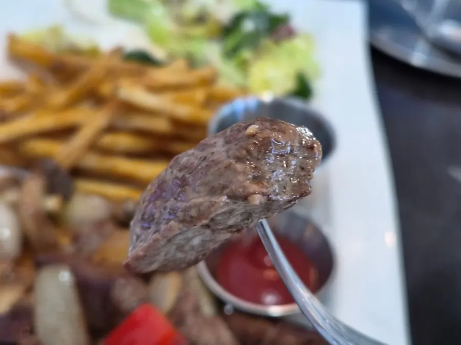 A piece of steak dipped in sauce