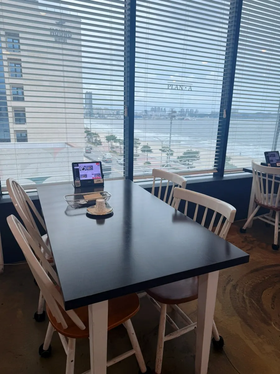 Restaurant interior with the ocean visible through floor-to-ceiling windows