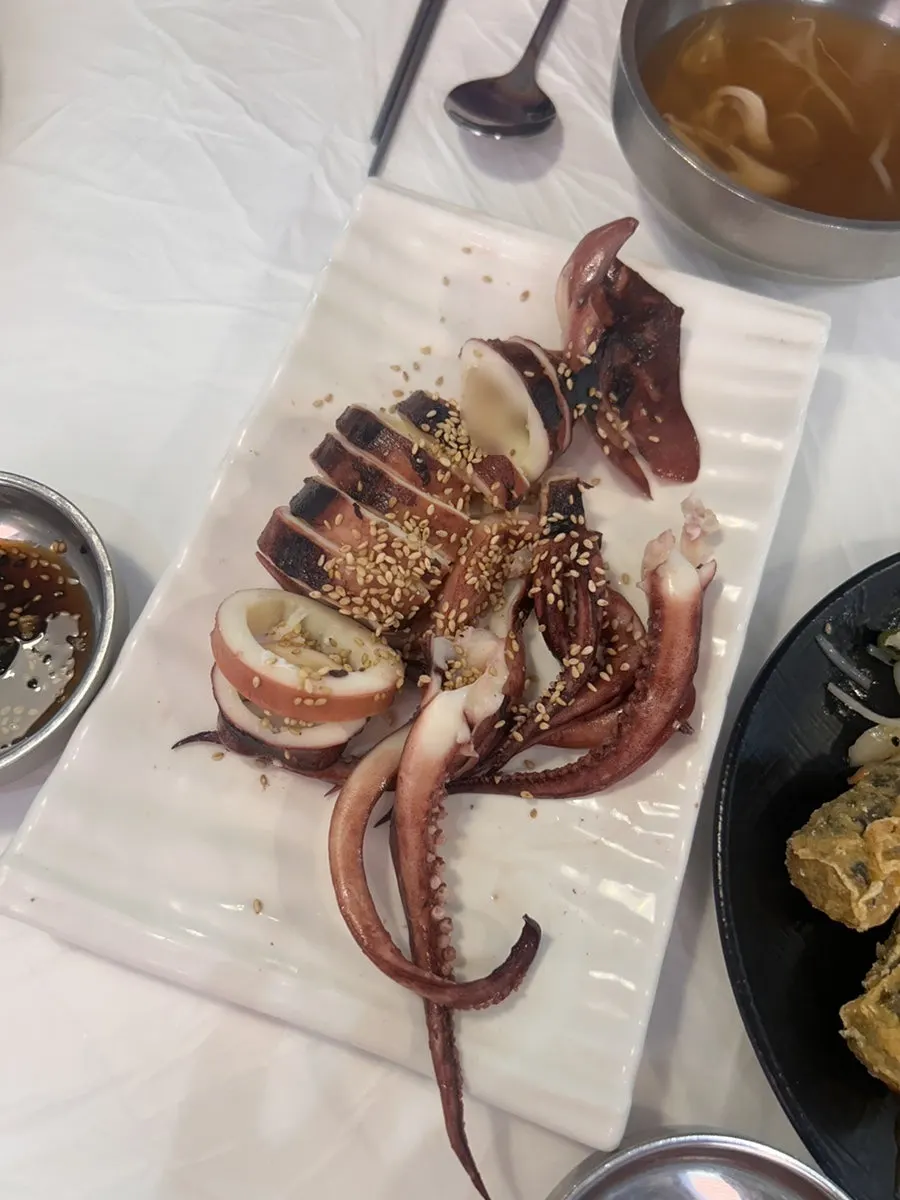 A spoonful of broth and seafood scooped together