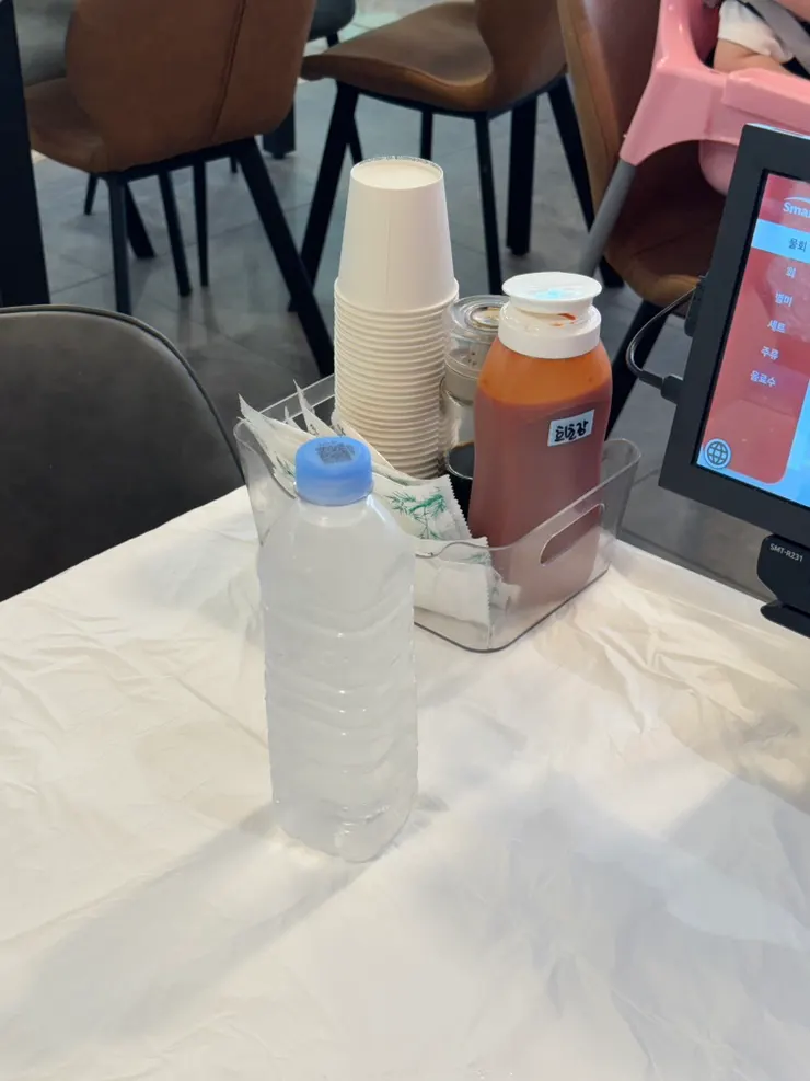 Table setting at Ppwang Mulhoe with water, chogochujang, and paper cups