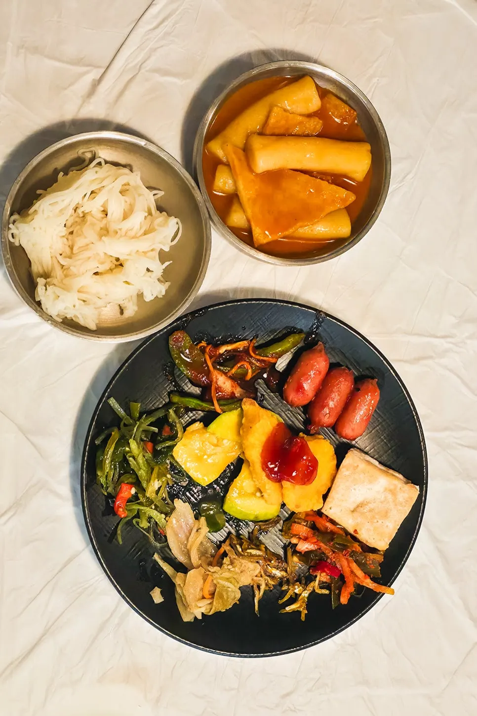 반찬 접시와 떡볶이, 소면 사리가 놓인 테이블